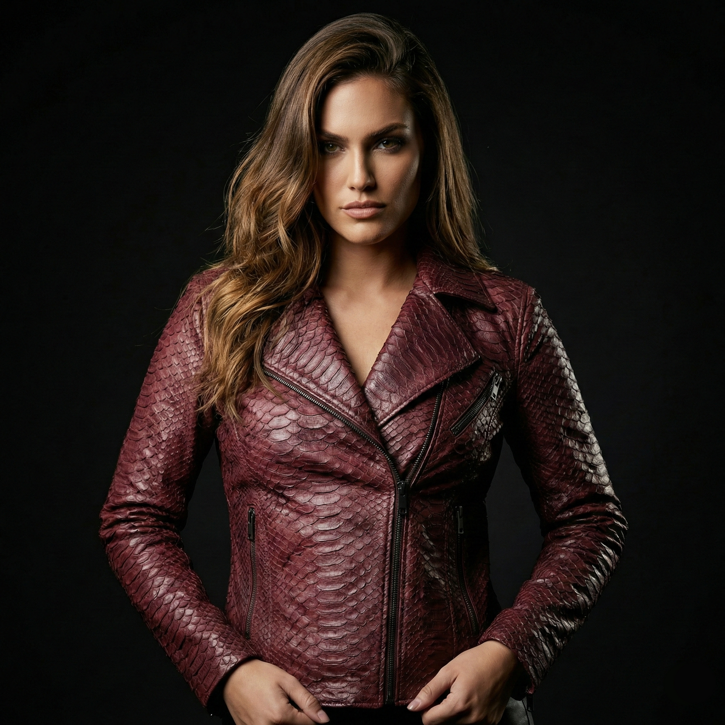 Woman wearing a maroon leather jacket against a black background