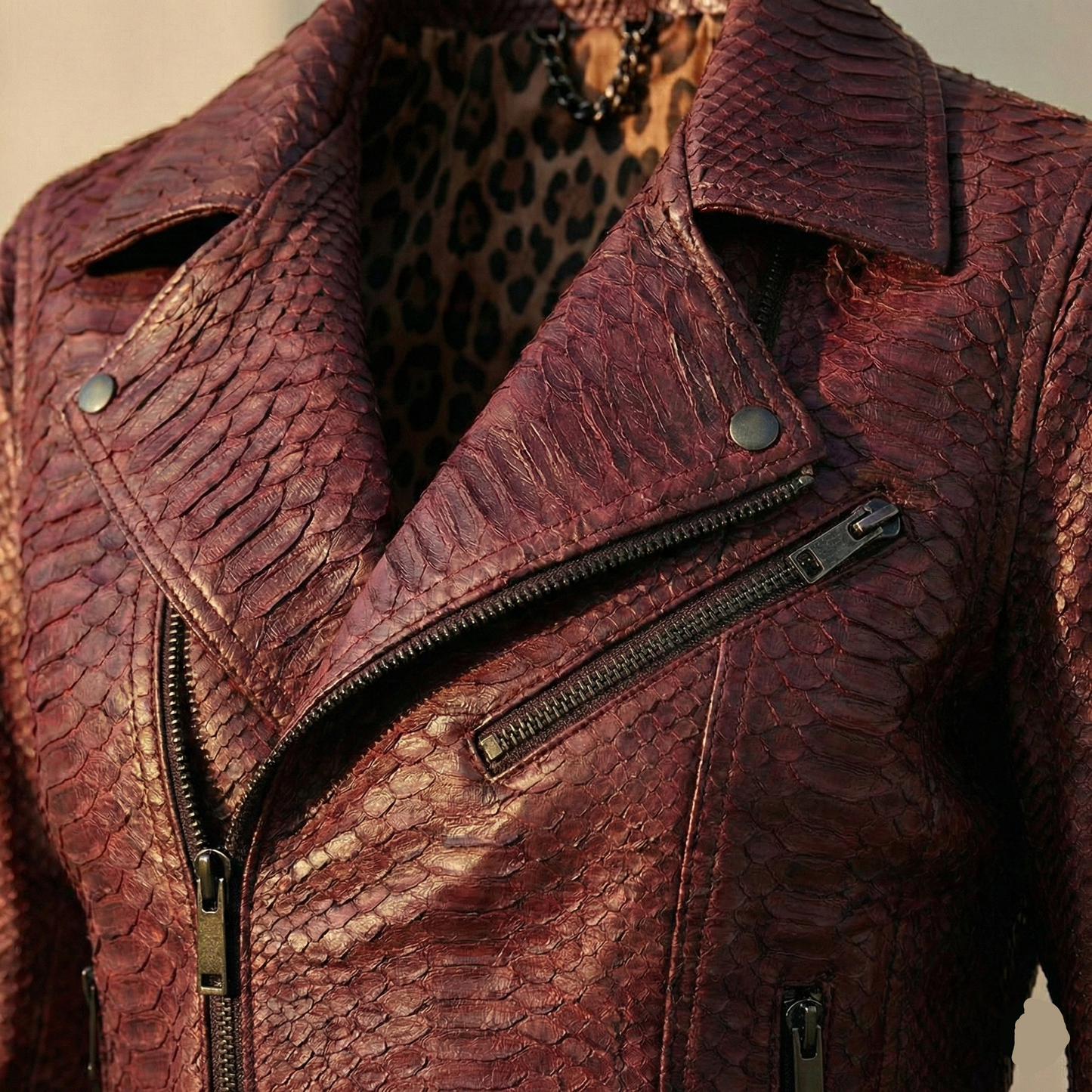 Close-up of a textured brown leather jacket with zippers.