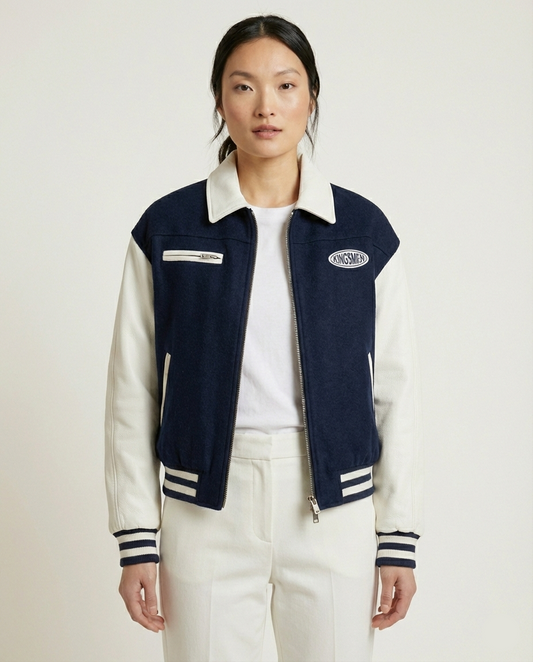 Person wearing a navy and white jacket with visible branding on a plain background