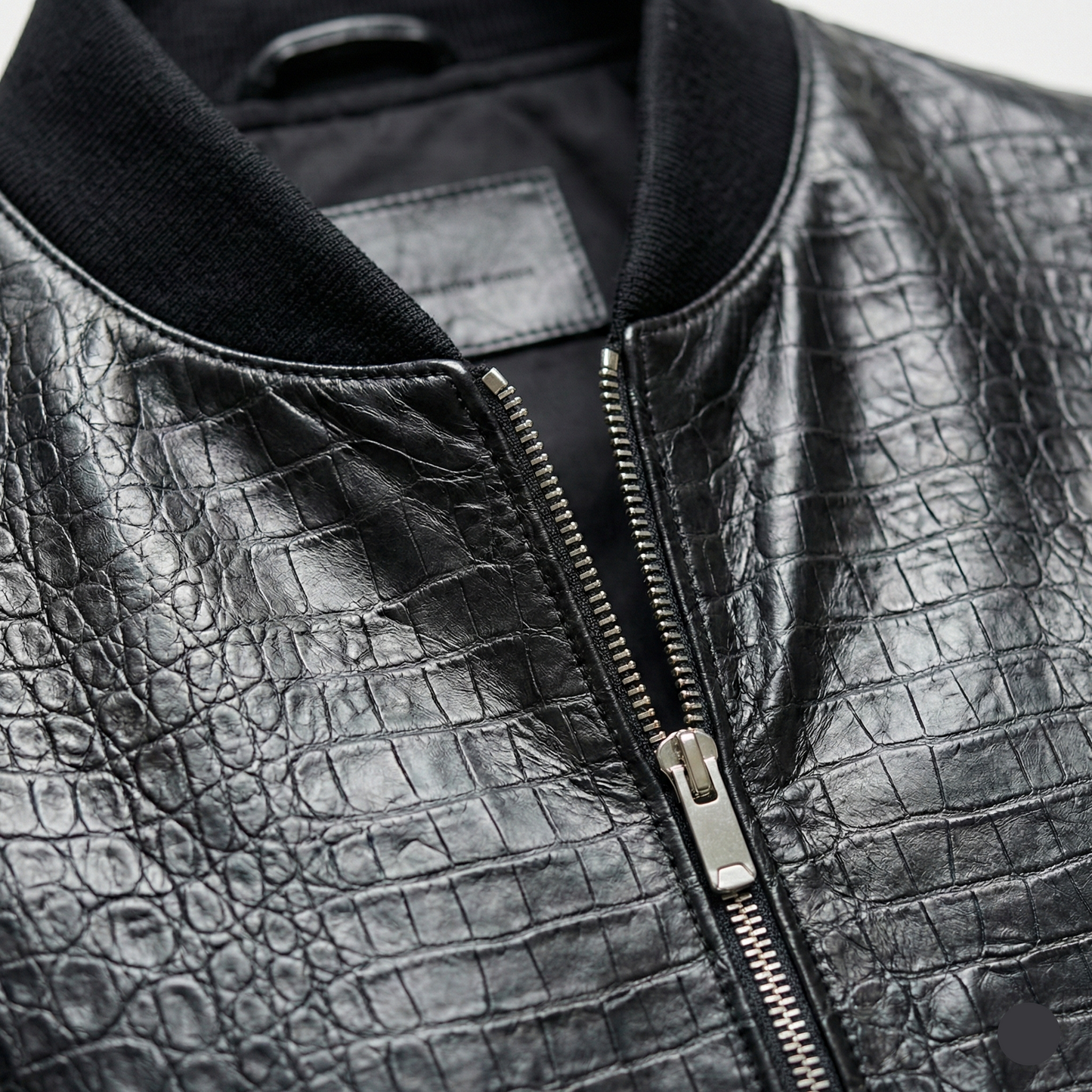 Close-up of a black leather jacket with a zipper
