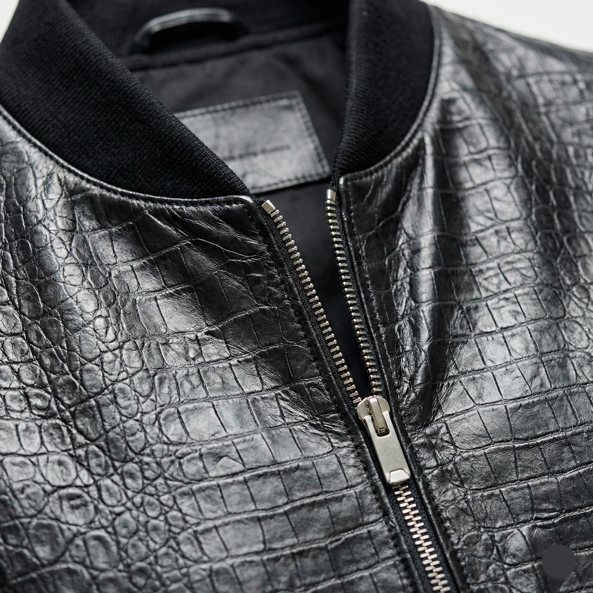 Close-up of a black leather jacket with a zipper