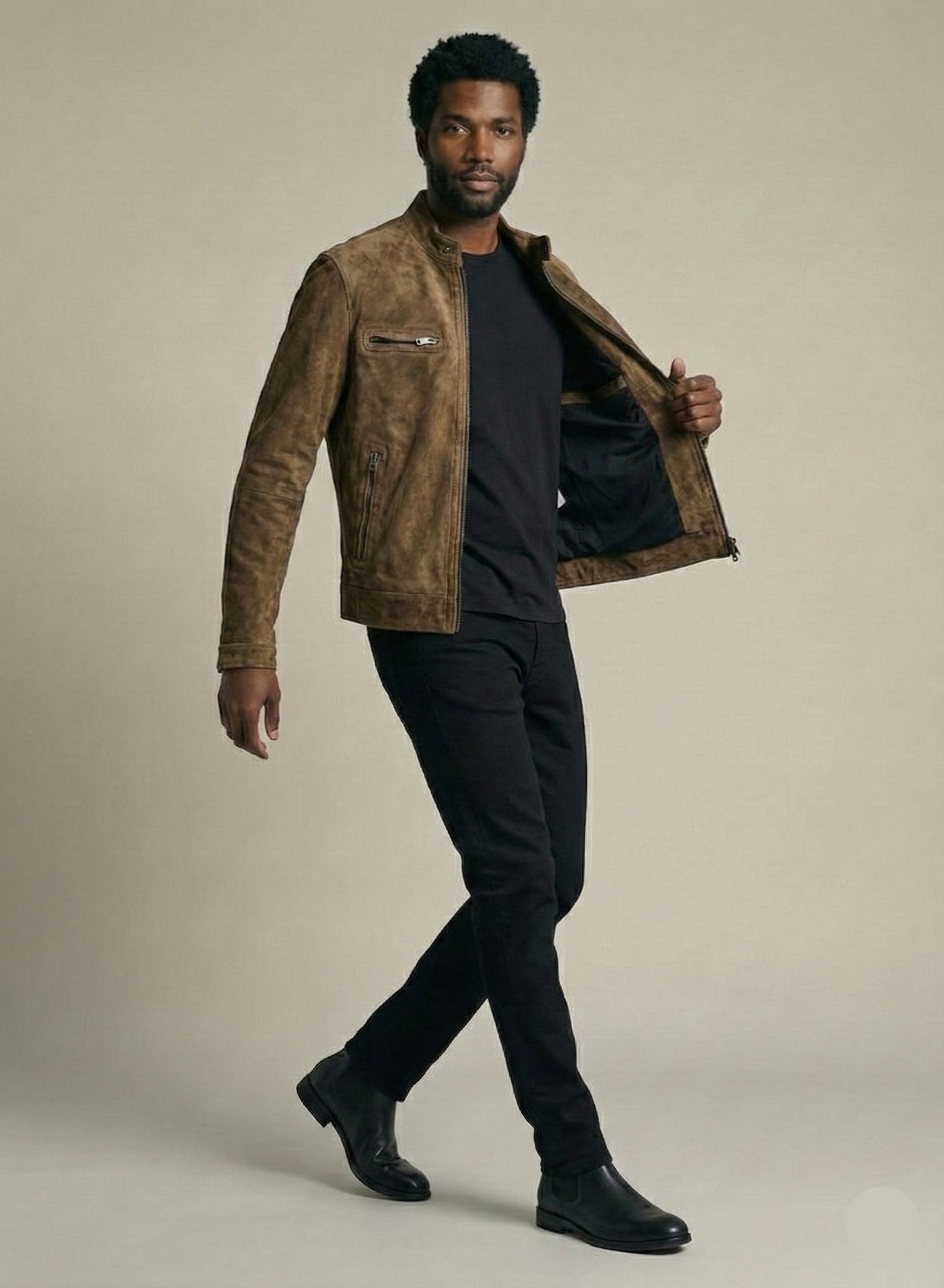 Man wearing a brown suede jacket over a black shirt on a beige background