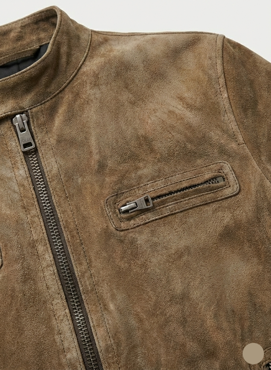 Close-up of a brown suede jacket with a zipper detail on a light gray background