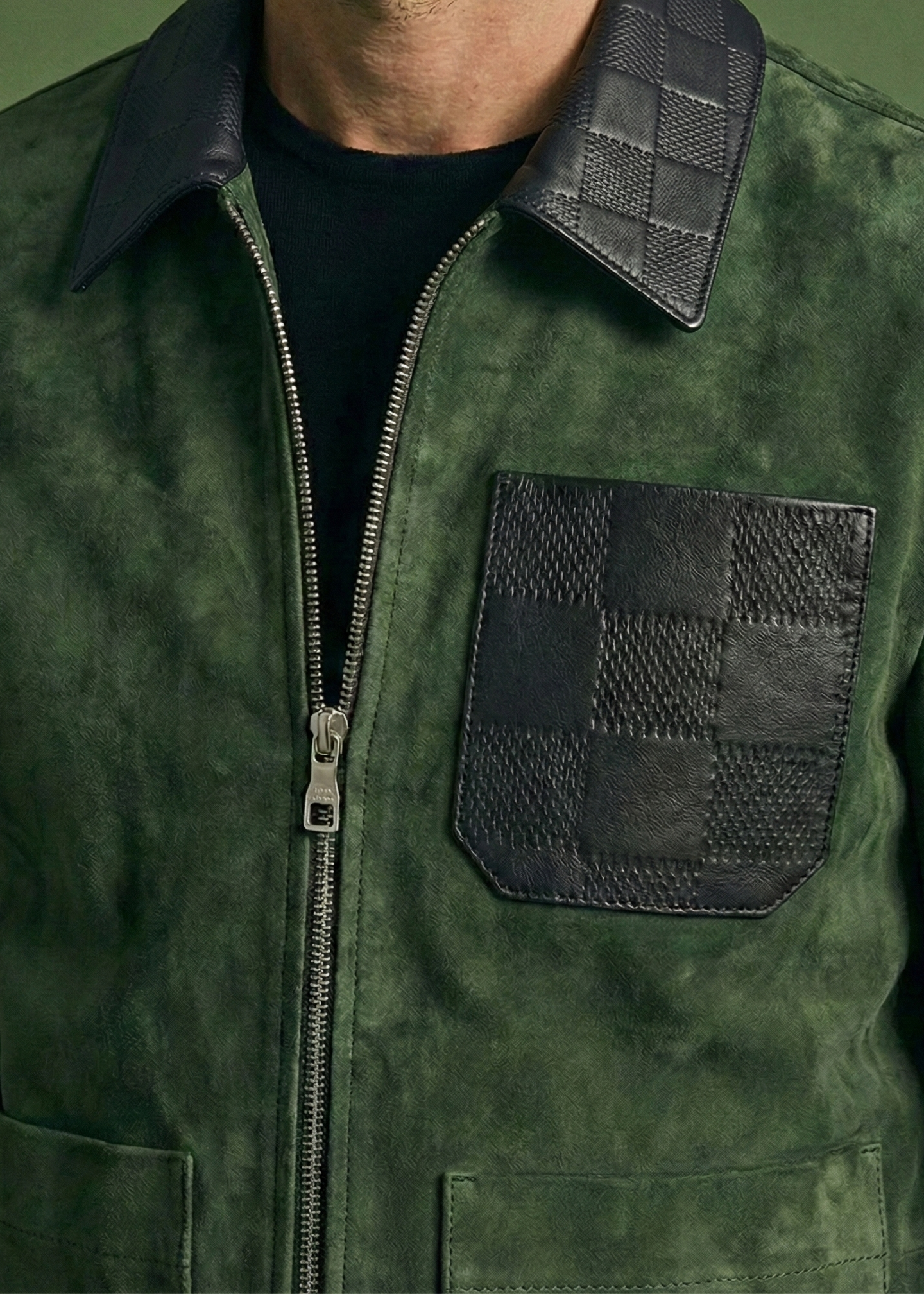 Men's green suede field jacket featuring a black checkered leather collar and chest pocket by Kingsmen Couture.