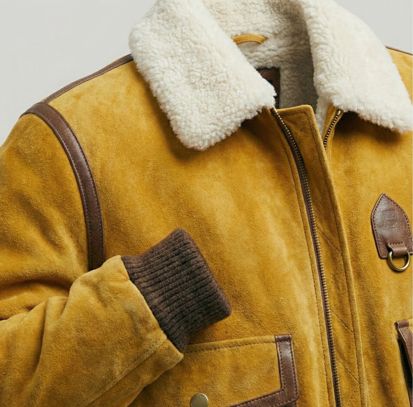 Tan suede aviator jacket with white shearling collar and ribbed cuffs by Kingsmen Couture.